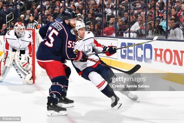 Mark Letestu of the Columbus Blue Jackets and Christian Djoos of the Washington Capitals battle for position as they skate after a loose puck during...