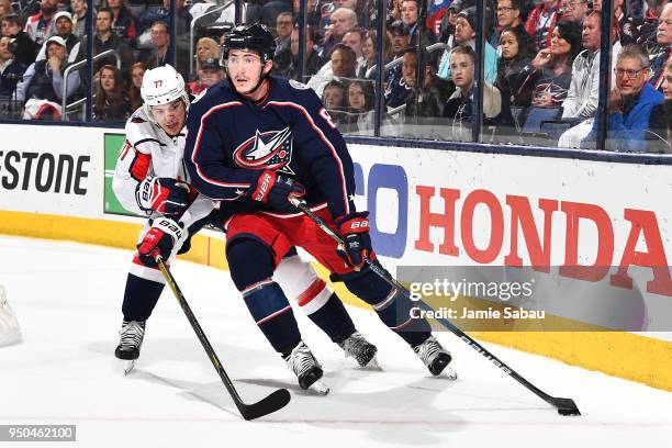 Zach Werenski of the Columbus Blue Jackets shields the puck from T.J. Oshie of the Washington Capitals during the first period in Game Six of the...