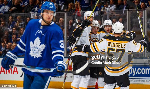 Jake DeBrusk of the Boston Bruins is congratulated by his teammates Zdeno Chara, Danton Heinen and Tommy Wingels as Auston Matthews of the Toronto...