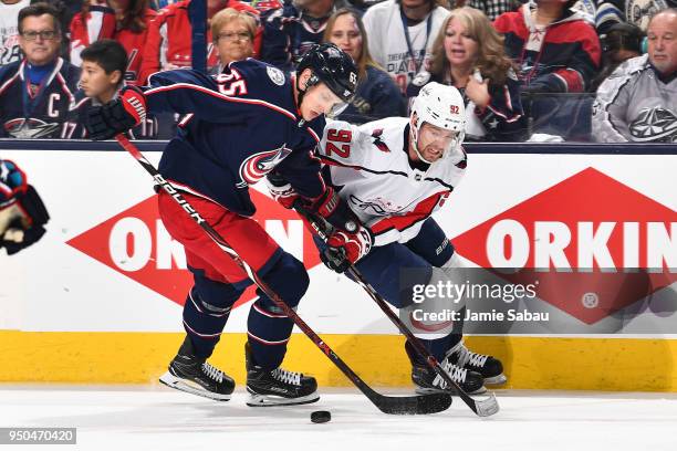 Markus Nutivaara of the Columbus Blue Jackets and Evgeny Kuznetsov of the Washington Capitals battle for the puck during the second period in Game...