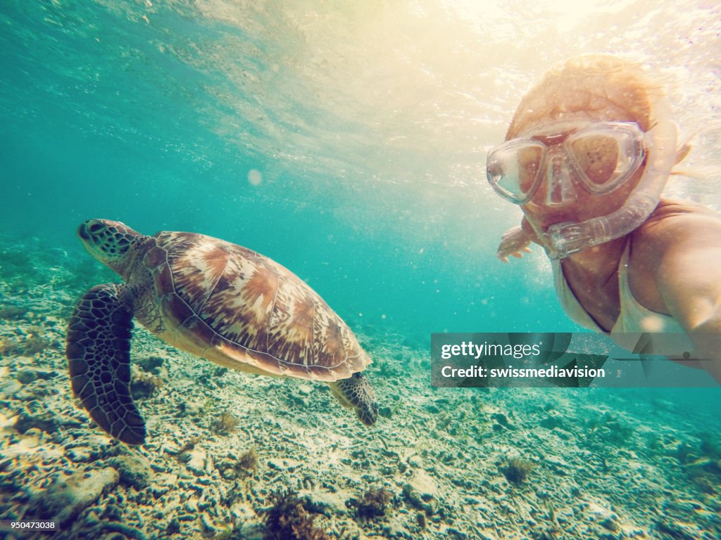 Selfie of girl with turtle underwater