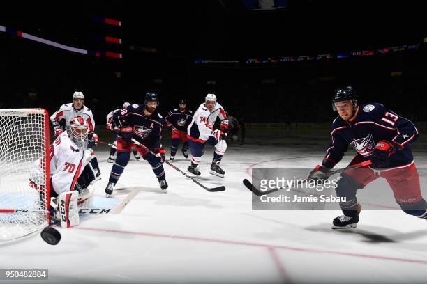 Cam Atkinson of the Columbus Blue Jackets skates after a loose puck as goaltender Braden Holtby of the Washington Capitals defends the net during the...