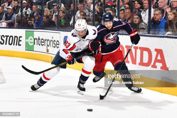 Jay Beagle of the Washington Capitals and Oliver Bjorkstrand of the Columbus Blue Jackets battle for a loose puck during the third period in Game Six...