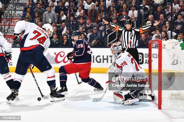 Goaltender Braden Holtby of the Washington Capitals defends the net as John Carlson of the Washington Capitals attempts to clear the puck away from...