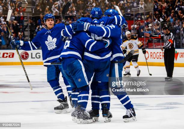 Tomas Plekanec of the Toronto Maple Leafs is congratulated after scoring an empty net goal on the Boston Bruins by teammates Jake Gardiner, Mitch...