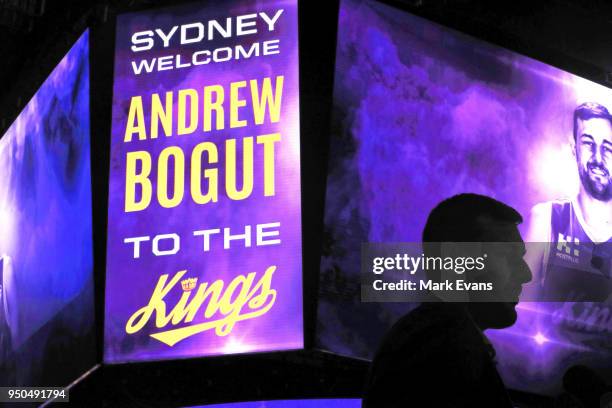 Andrew Bogut is silhouetted against a big screen during a media conference as he is unveiled as a Sydney Kings player at Qudos Bank Arena on April...