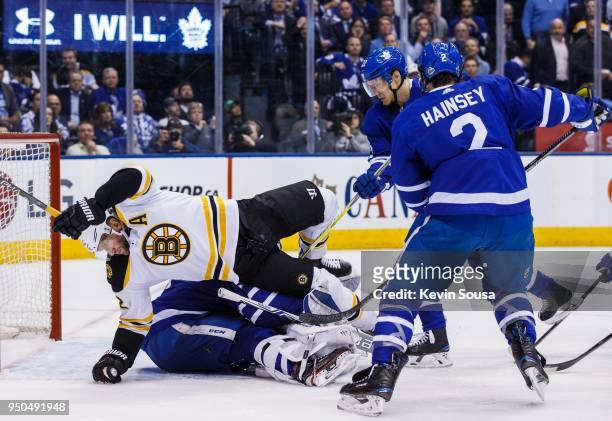 David Backes of the Boston Bruins falls over Frederik Andersen of the Toronto Maple Leafs as Nikita Zaitsev and Ron Hainsey of the Toronto Maple...