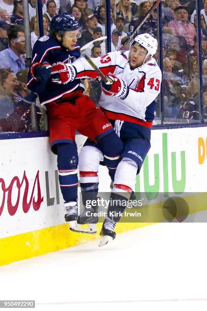 Tom Wilson of the Washington Capitals collides with Artemi Panarin of the Columbus Blue Jackets while chasing after the puck during the second period...