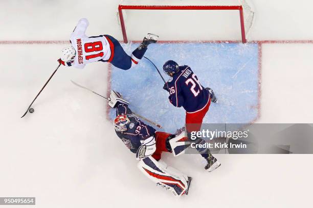 Chandler Stephenson of the Washington Capitals attempts to shoo the puck on Sergei Bobrovsky of the Columbus Blue Jackets as Thomas Vanek of the...