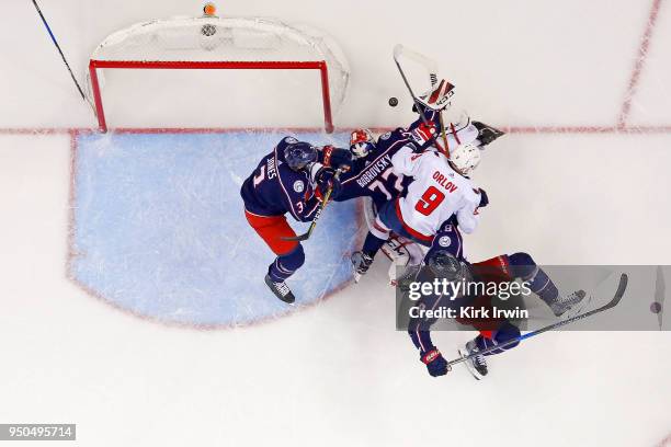 Sergei Bobrovsky of the Columbus Blue Jackets dives on a loose puck in an attempt to keep the puck from Dmitry Orlov of the Washington Capitals in...