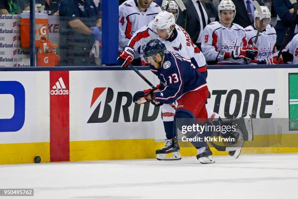 Cam Atkinson of the Columbus Blue Jackets and Nicklas Backstrom of the Washington Capitals chase after a loose puck in Game Four of the Eastern...