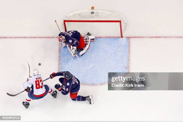 Zach Werenski of the Columbus Blue Jackets attempts to keep Jay Beagle of the Washington Capitals from getting a shot off on Sergei Bobrovsky of the...