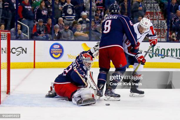 Zach Werenski of the Columbus Blue Jackets plays defense as Sergei Bobrovsky of the Columbus Blue Jackets stops a shot from Jay Beagle of the...