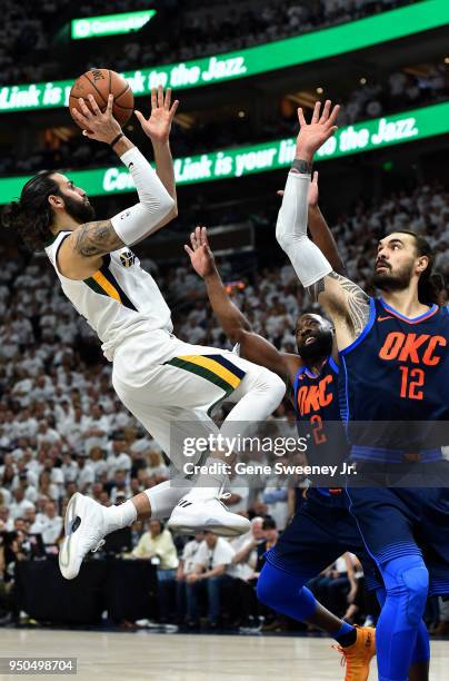 Ricky Rubio of the Utah Jazz shoots over Steven Adams and Raymond Felton of the Oklahoma City Thunder in the first half during Game Four of Round One...