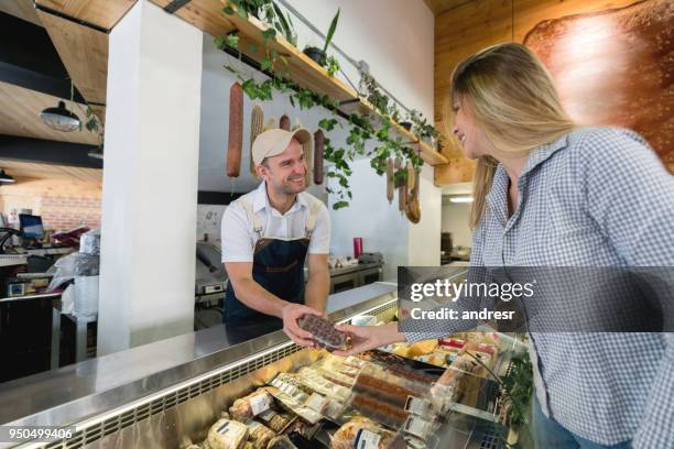 vrouw winkelen bij de delicatessen-sectie in de supermarkt - cheesy salesman stockfoto's en -beelden