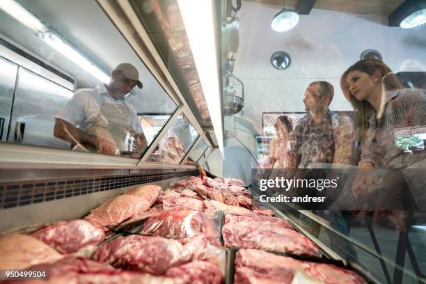 menschen kaufen fleisch bei der metzgerei - metzgerin stock-fotos und bilder