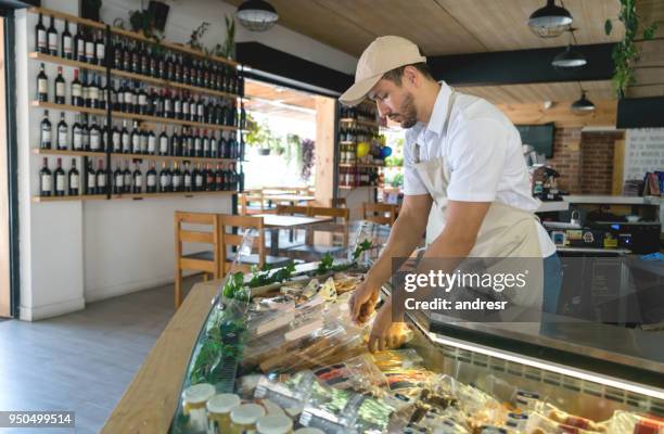 hombre feliz trabajando en una tienda de delicatessen - charcutería-italiana fotografías e imágenes de stock
