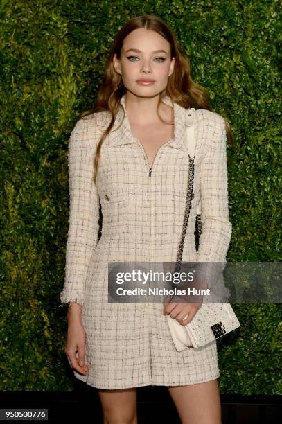 Kristine Froseth wears an ecru and pink fantasy tweed jumpsuit, Look 4, from the Spring-Summer 2018 Act 1 Ready-to-Wear Collection and CHANEL Shoes...
