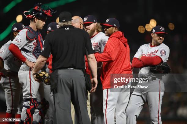 Shawn Kelley of the Washington Nationals is looked at by the trainer after he injured himself in the sixth inning against the San Francisco Giants at...