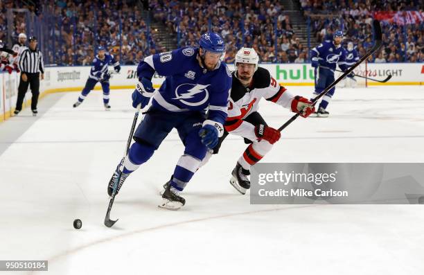 Miller of the Tampa Bay Lightning fights off the check of Marcus Johansson of the New Jersey Devils in the second period of Game Five of the Eastern...