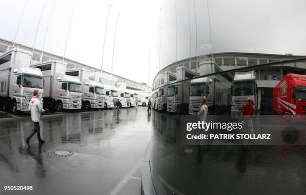People walking in the paddock of the Nuerburgring racetrack are reflected on the McLaren-Mercedes motorhome, 20 July 2007 in Nuerburgring, before the...