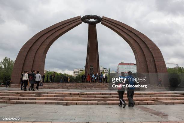 Pedestrians walk near Victory Monument at Victory Square in Bishkek, Kyrgyzstan, on Wednesday, April 18, 2018. Bishkek is the capital and largest...