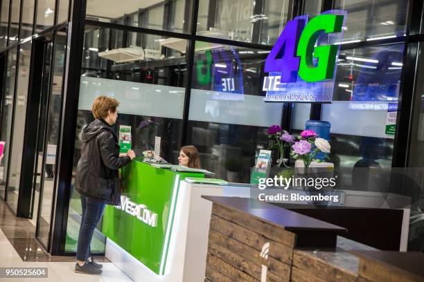 Woman stands at a MegaCom Ltd. Counter inside the Asia Mall shopping and entertainment center in Bishkek, Kyrgyzstan, on Friday, April 20, 2018....