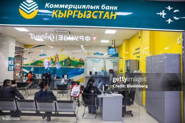 Employees attend to customers at a Commercial Bank Kyrgyzstan branch inside the Asia Mall shopping and entertainment center in Bishkek, Kyrgyzstan,...