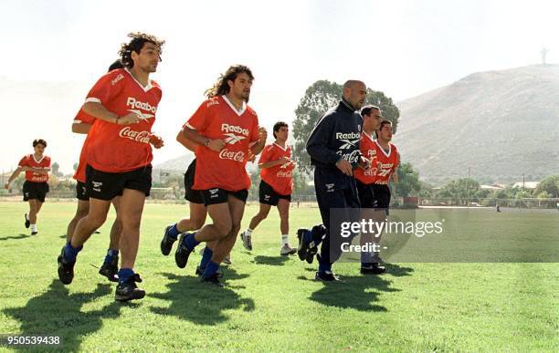 , junto a otros jugadores del seleccionado de futbol de Chile, corren el 12 Junio, durante la practica que efectuaron en el campo de deportes de la...