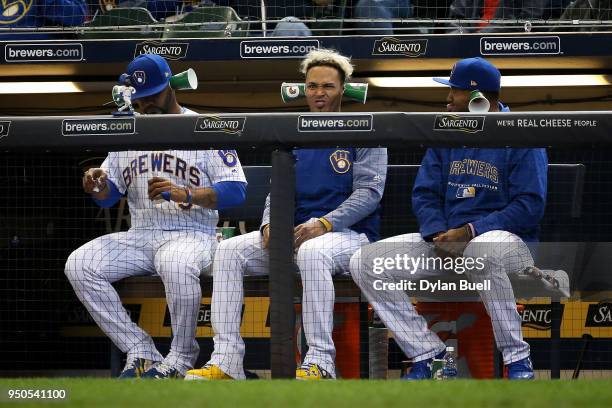 Jonathan Villar, Orlando Arcia, and Domingo Santana of the Milwaukee Brewers look on from the dugout in the fourth inning against the Miami Marlins...