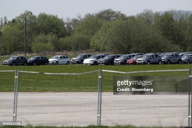New Peugeot 3008 sports utility vehicles and Peugeot 308 automobiles, manufactured by PSA Group, sit parked on an airfield near Belfort, France, on...