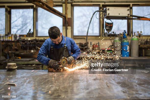 Worker saws metal in a blacksmith shop on April 03, 2018 in Klitten, Germany.