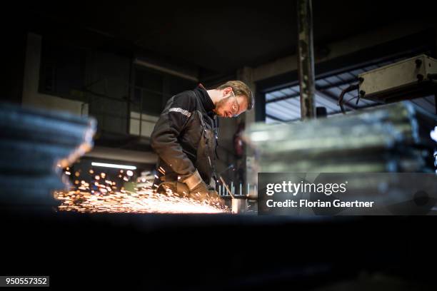 Young worker grinds metal in the workshop of a blacksmith on April 03, 2018 in Klitten, Germany.