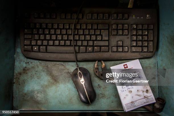 Dirty mouse, keyboard and a notepad with handwritten notes in the workshop of a blacksmith on April 03, 2018 in Klitten, Germany.