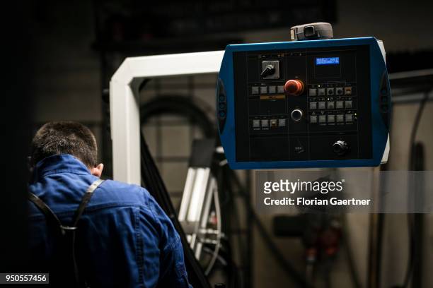 Worker is standing next to an electronic control panel in the workshop of a blacksmith on April 03, 2018 in Klitten, Germany.