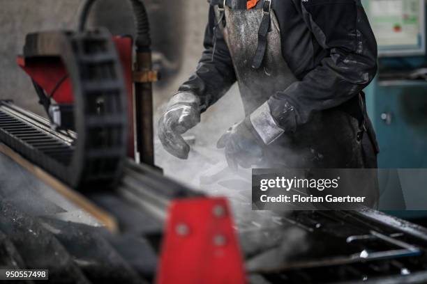 Worker works on a laser cutter in the workshop of a blacksmith on April 03, 2018 in Klitten, Germany.