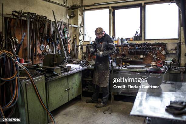 Young worker works in the workshop of a blacksmith on April 03, 2018 in Klitten, Germany.