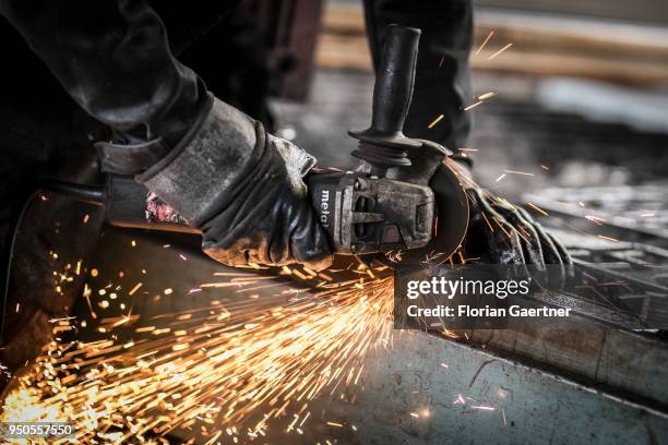 Worker cuts metal in the workshop of a blacksmith on April 03, 2018 in Klitten, Germany.