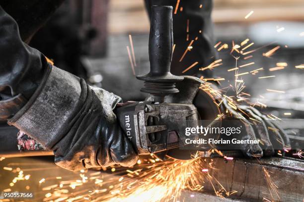 Worker cuts metal in the workshop of a blacksmith on April 03, 2018 in Klitten, Germany.