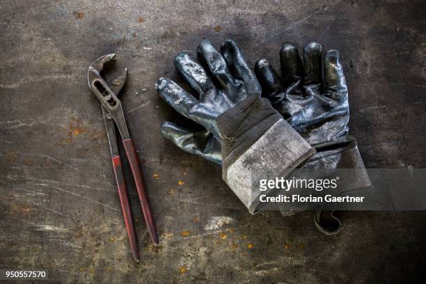 Closeup of a pair of work gloves and pliers taken in a blacksmith shop on April 03, 2018 in Klitten, Germany.