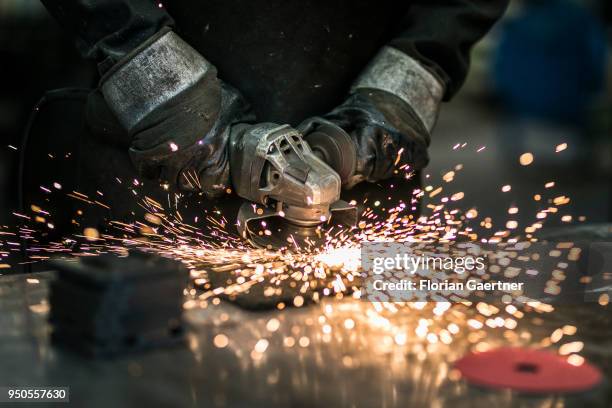 Worker grinds a metal plate in the workshop of a blacksmith on April 03, 2018 in Klitten, Germany.