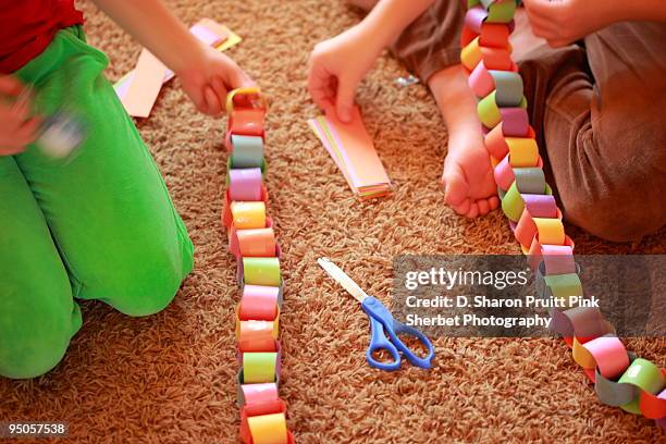 children assembling holiday paper chains - paper chain stock pictures, royalty-free photos & images