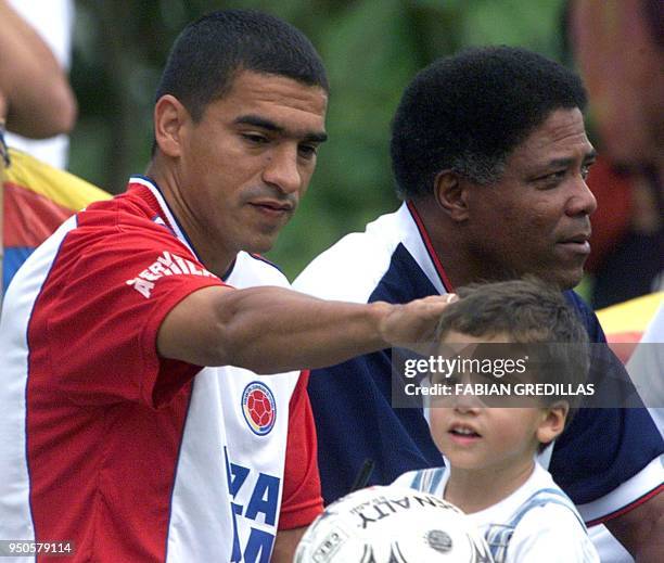 Colombia's Victor Ariztizabal and head coach Pacho Maturana , greet a child after signing an autograph before a practice 27 July 2001 in Armenia,...