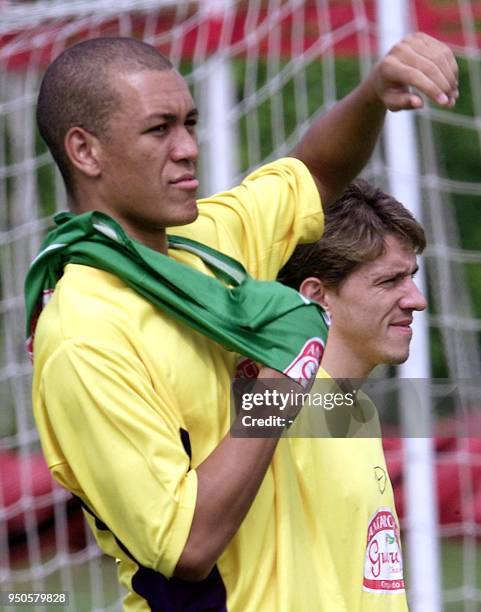 Brazilian soccer player Eduardo Costa puts on a jersey, next to his teammate Juninho Paulista, 14 July 2001, during a practice in Cali, Colombia....