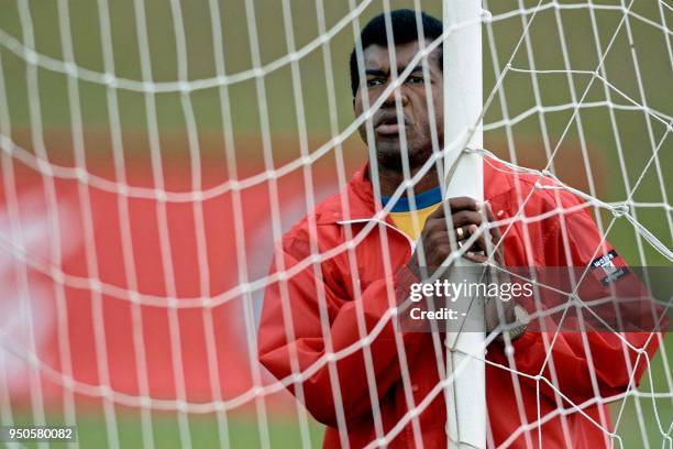 Julio Cesar Uribe, head coach of the Peruvian soccer team, watches his players from behind a goalpost, 13 July 2001, during a practice at Los...