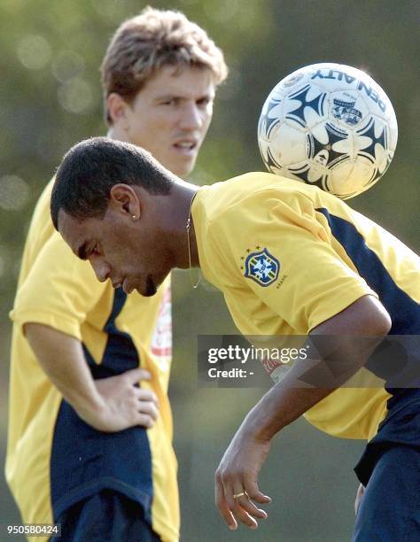 Denilson , striker of the Brazilian soccer team, controls the ball, watched by Juninho Paulista, 10 July 2001, during Brazil's first practice for the...
