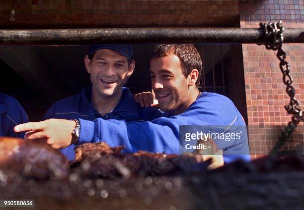 Omar Luis Rodriguez and Jose Saturnino Cardozo, of Mexico's Cruz Azul, prepare to eat an Argentine barbecue at the Independiente Club in Buenos...
