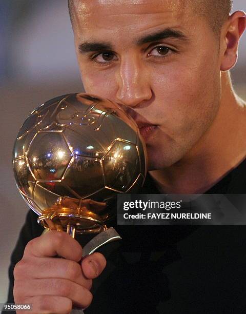 Algerian national and Scotland's Ranger team football player Madjid Bougherra kisses his 'Golden Ball' trophy of best Algerian player for 2009 during...