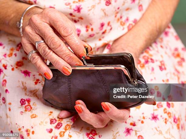 70 year old woman's hands opening purse - pensioen thema stockfoto's en -beelden