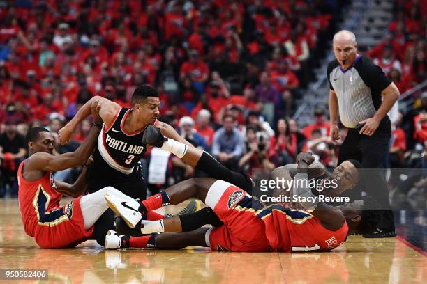 Jrue Holiday of the New Orleans Pelicans and CJ McCollum of the Portland Trail Blazers grab a loose ball during the first half of Game Four of the...